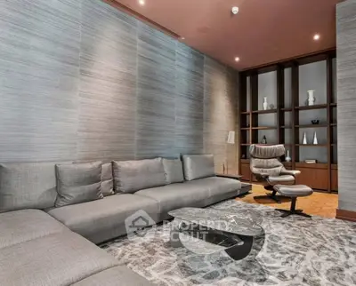 Luxurious modern living room with elegant gray sofa and stylish armchair, perfect for relaxation.