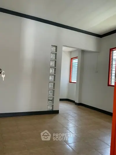 Spacious interior room with tiled flooring and modern window design