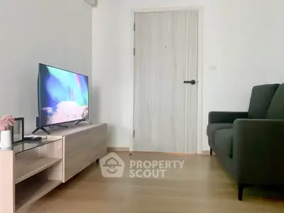Modern living room with sleek TV setup and cozy sofa in minimalist apartment.