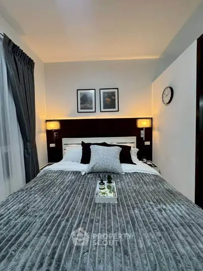 Cozy bedroom with elegant decor and soft lighting, featuring a plush bed and stylish wall art.