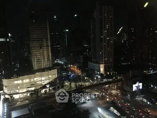 Stunning cityscape view from high-rise building at night with illuminated skyline and bustling streets.