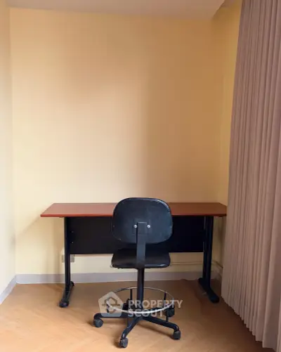 Minimalist study area with desk and chair in a cozy corner, perfect for focused work or study sessions.
