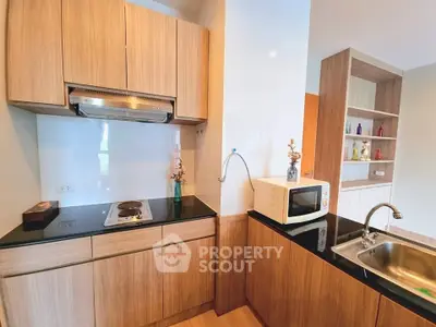Modern kitchen with sleek wooden cabinets and built-in appliances in a stylish apartment.