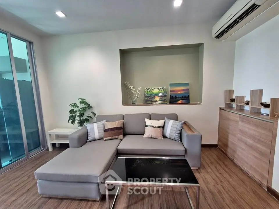 Modern living room with stylish furniture and elegant decor, featuring a cozy sectional sofa and sleek wooden flooring.