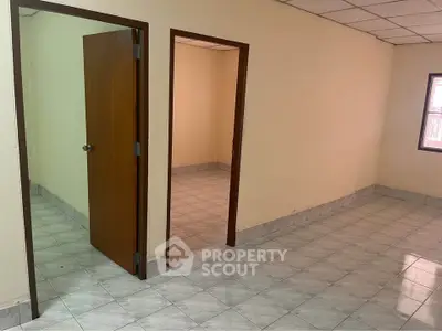 Spacious interior with tiled flooring and open doorways, ideal for customization.