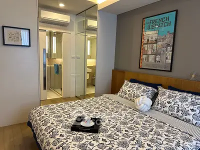 Stylish bedroom with modern decor and ensuite bathroom in a chic apartment.