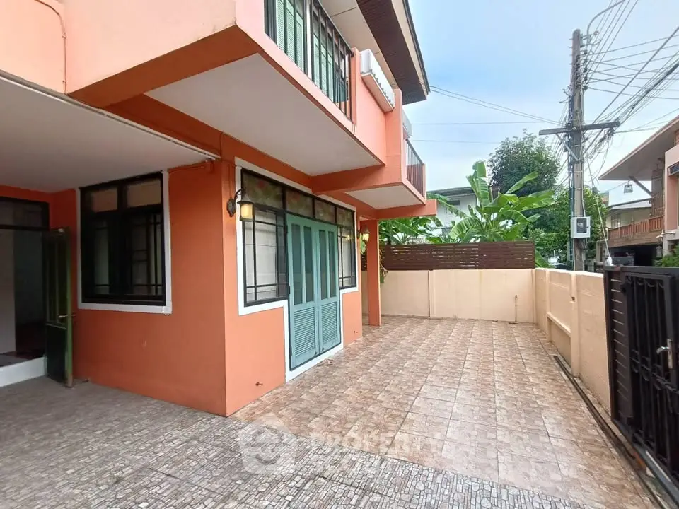 Charming two-story home with spacious tiled patio and vibrant exterior.