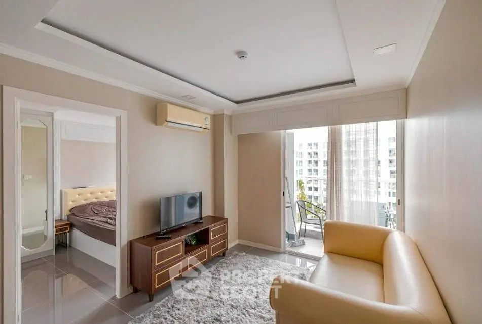 Modern living room with beige sofa, TV, and balcony view in a stylish apartment.