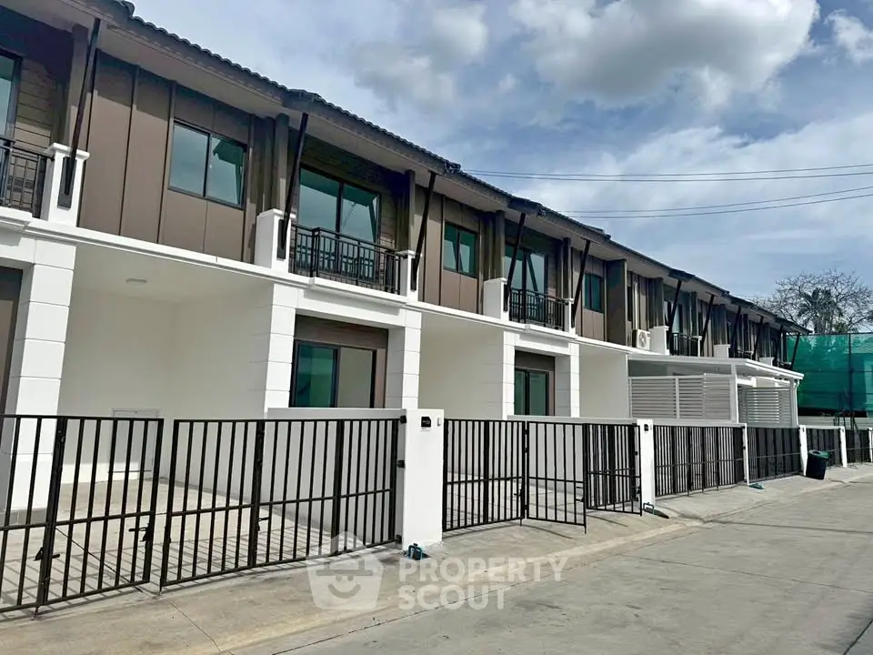 Modern townhouse exterior with sleek design and gated entrance in a serene neighborhood.