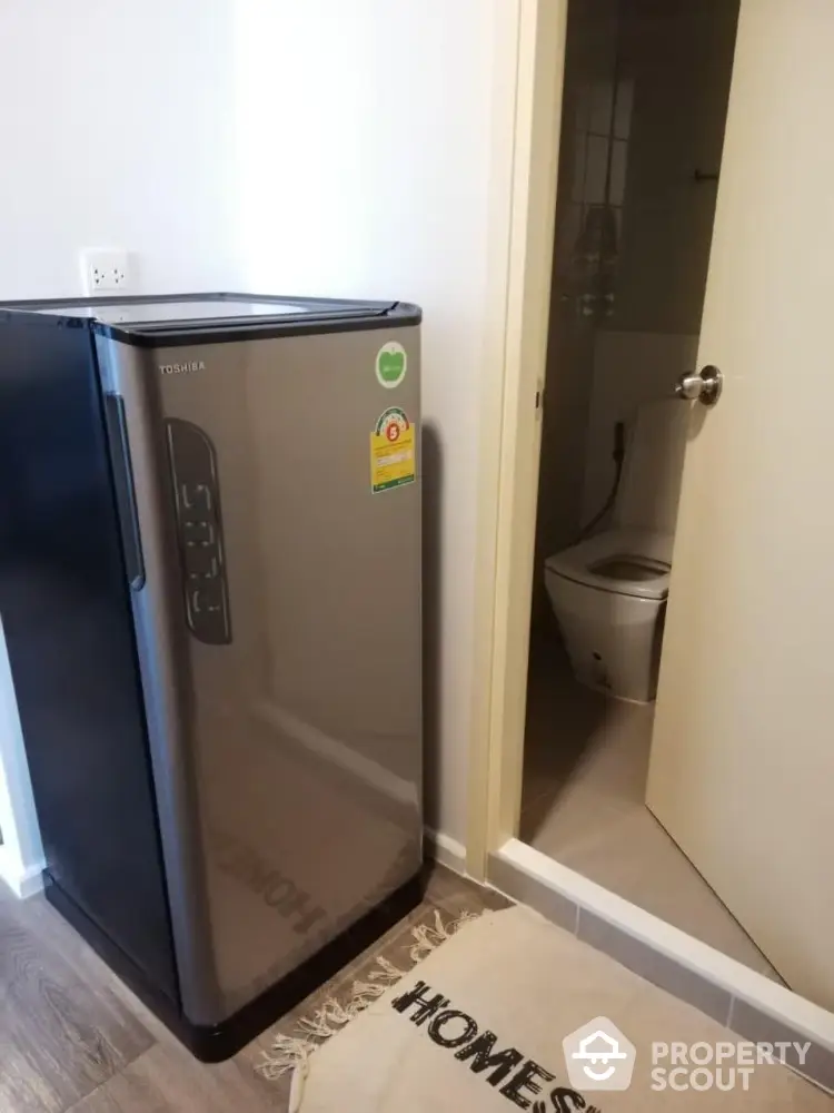 Compact fridge near bathroom in modern apartment