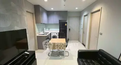 Modern apartment interior with open kitchen and living area, featuring sleek furniture and appliances.