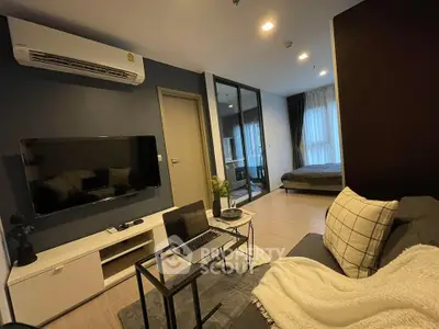 Modern living room with sleek furniture and open view to bedroom