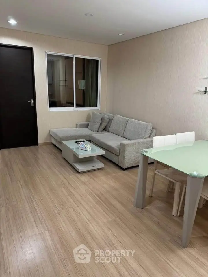 Modern living room with sleek furniture and wooden flooring, perfect for cozy gatherings.