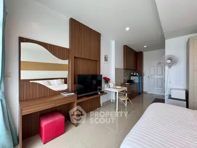 Modern studio apartment with stylish wood paneling and open layout, featuring a cozy bed and sleek TV setup.
