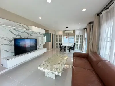 Luxurious living room with marble accents and modern furnishings, featuring a spacious layout and elegant design.