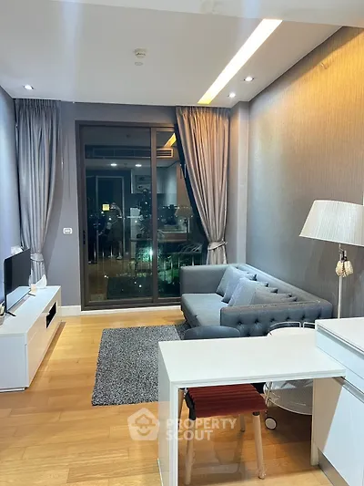 Modern living room with stylish decor and city view, featuring a cozy sofa and sleek furniture.