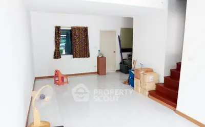 Spacious living room with minimalist decor and staircase, ideal for customization.