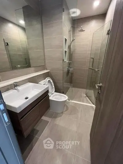 Modern bathroom with sleek design, glass shower, and stylish fixtures in a contemporary apartment.
