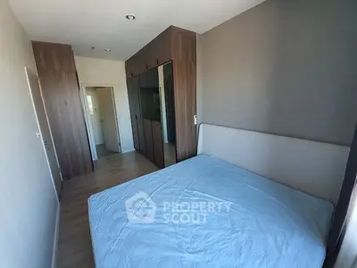 Spacious bedroom with large mirrored wardrobe and modern design, featuring a comfortable double bed and ample natural light, perfect for relaxation.