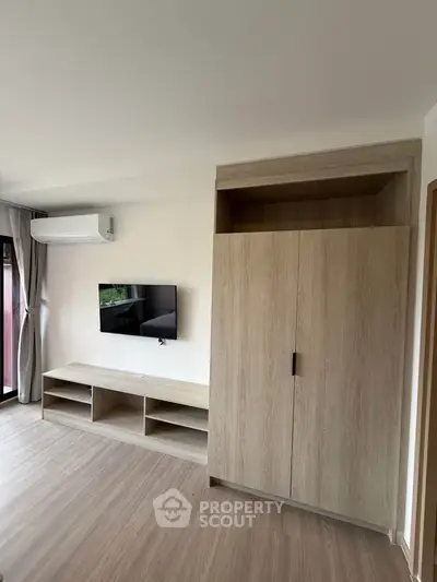 Modern living room with sleek wooden furniture and wall-mounted TV