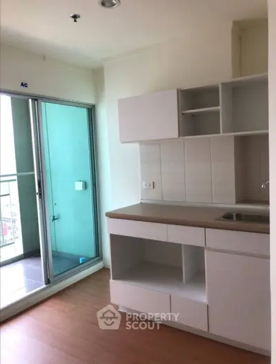 Modern kitchen with open layout and balcony access in a bright apartment.