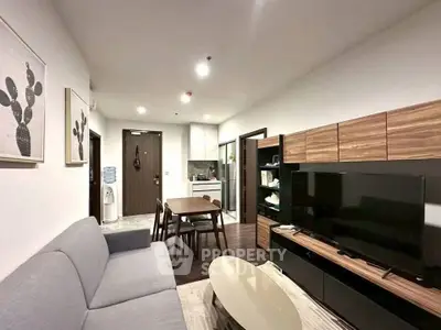 Modern living room with sleek furniture and open kitchen layout in a stylish apartment.