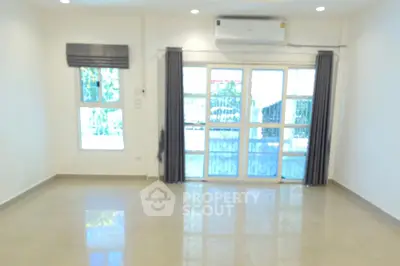 Spacious living room with large windows and air conditioning