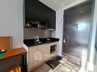 Modern compact kitchen with sleek cabinetry and built-in appliances in a stylish apartment.