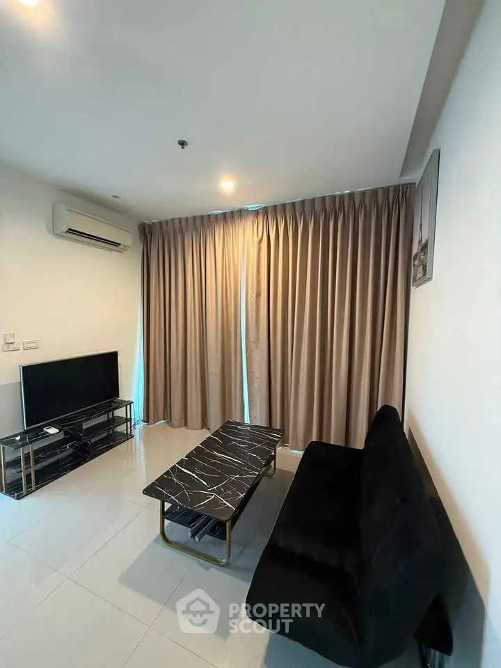 Modern living room with sleek black sofa, marble coffee table, and wall-mounted TV.