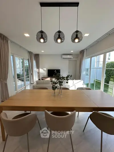 Modern living room with elegant dining area and large windows for natural light