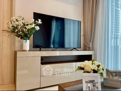 Modern living room with sleek TV stand, large flat-screen TV, and elegant decor.