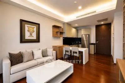 Modern living room with open kitchen, stylish decor, and wooden flooring in a cozy apartment.