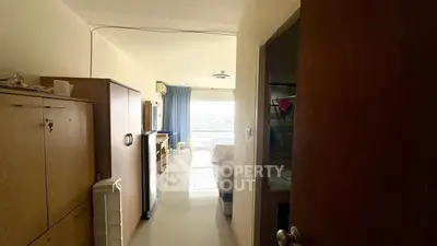 Spacious living area with natural light and modern furnishings in a cozy apartment.
