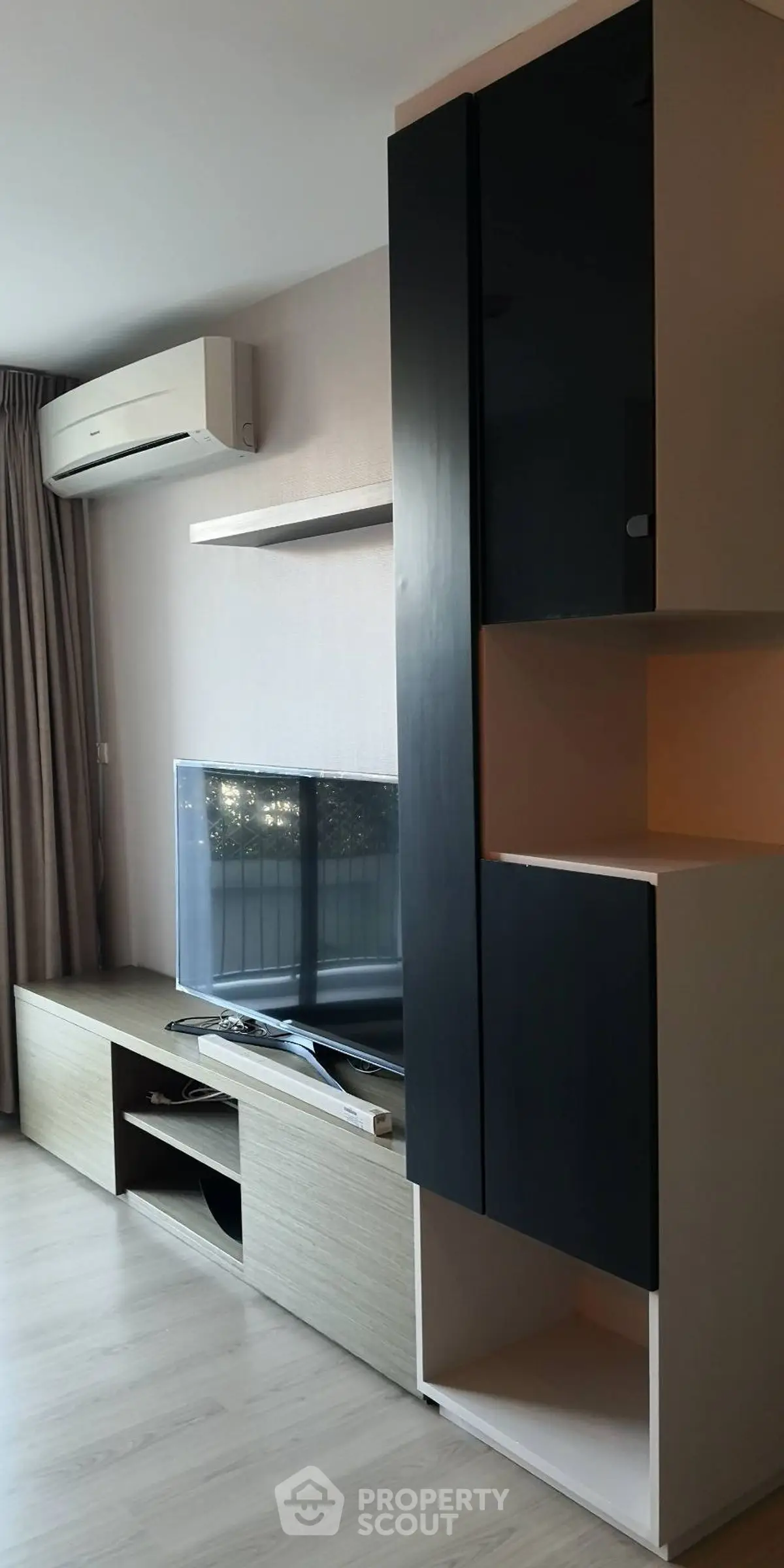 Modern living room with sleek TV unit and air conditioning, perfect for cozy entertainment.
