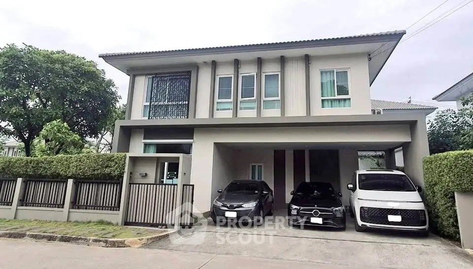 Modern two-story house with spacious driveway and three parked cars