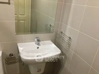 Modern bathroom with sleek sink and mirror in a compact space.