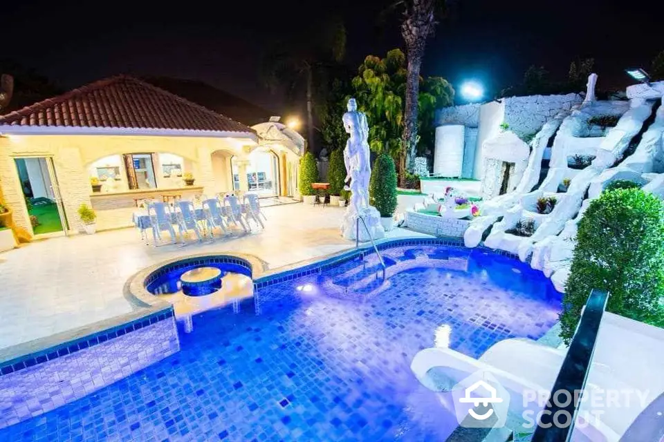 Luxurious villa with illuminated pool and elegant outdoor seating area at night