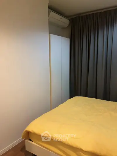 Cozy bedroom with yellow bedding and modern air conditioning unit.