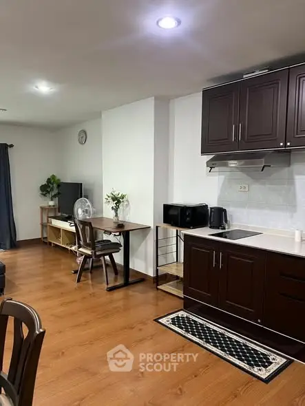 Charming open-layout kitchen and living area with wooden flooring and modern appliances.