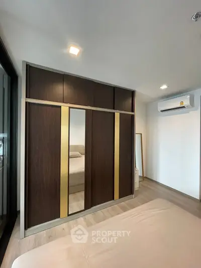 Modern bedroom with sleek wardrobe and air conditioning unit