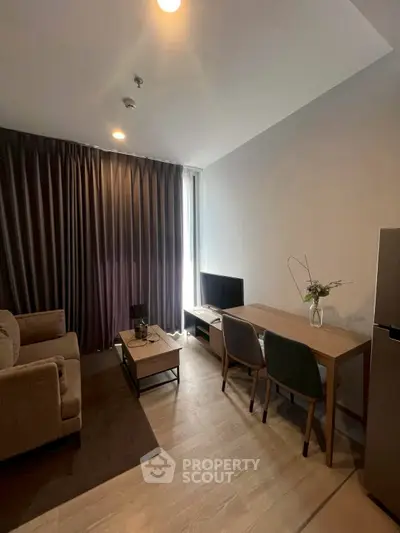 Modern living room with cozy sofa, TV, and dining area in stylish apartment.