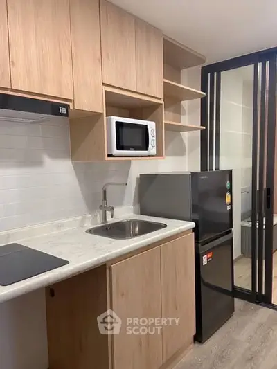 Modern kitchen with sleek cabinets and appliances in a compact space