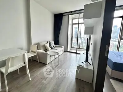 Modern living room with city view and balcony access, featuring sleek furniture and natural light.
