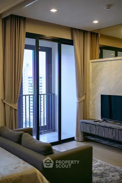 Modern living room with balcony view, featuring sleek furniture and elegant curtains.