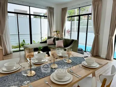 Elegant dining area with pool view, featuring modern decor and large windows for natural light.