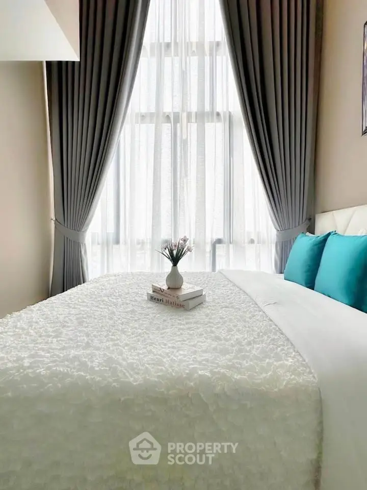 Elegant bedroom with plush bedding and floor-to-ceiling windows for natural light.