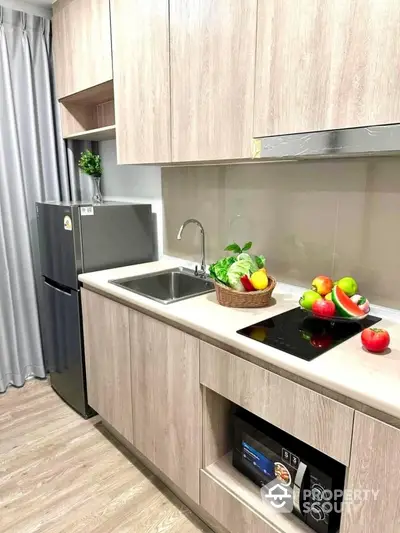 Modern kitchen with sleek cabinets, induction stove, and fresh produce on countertop