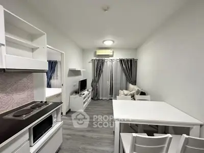 Modern living room with open kitchen, featuring sleek white furniture and stylish decor.