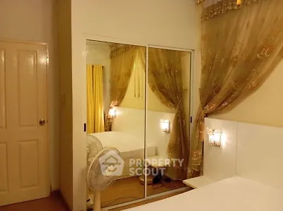 Cozy bedroom with mirrored closet and elegant drapes
