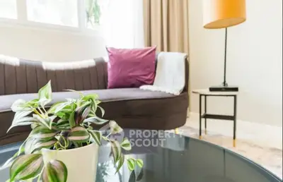 Stylish living room with modern sofa, vibrant cushion, and elegant decor.